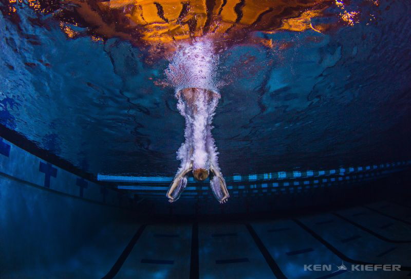 Diver from a high dive entering the water in a way to min... by Ken Kiefer 