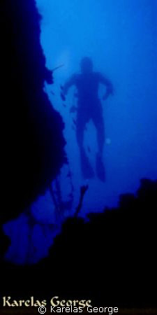 Diver's silhouette at the vertical rocks
of Camping Tsol... by Karelas George 