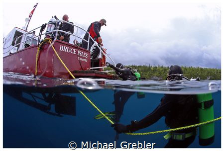 Divers board the dive boat shortly after the passing of a... by Michael Grebler 
