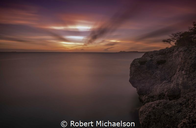 Dive Site Oil Slick in Bonaire just after sunset. by Robert Michaelson 