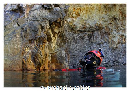 Diver at the surface in the cavern section of a flooded m... by Michael Grebler 