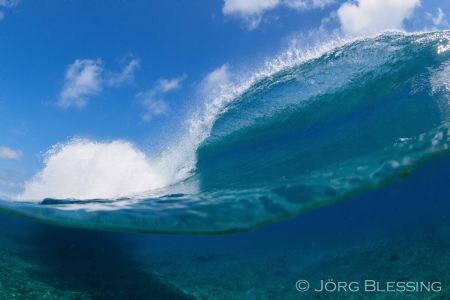 Wave breaking over reef by Joerg Blessing 
