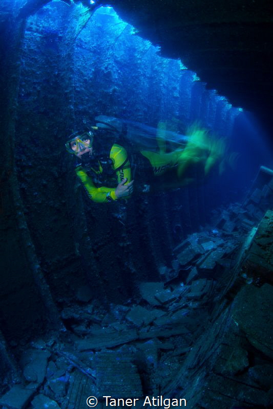 Speeding diver inside the wreck - long exposure by Taner Atilgan 