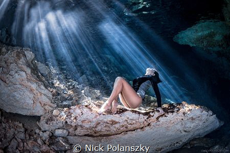 Freediver basking in the sun rays beaming through the sur... by Nick Polanszky 