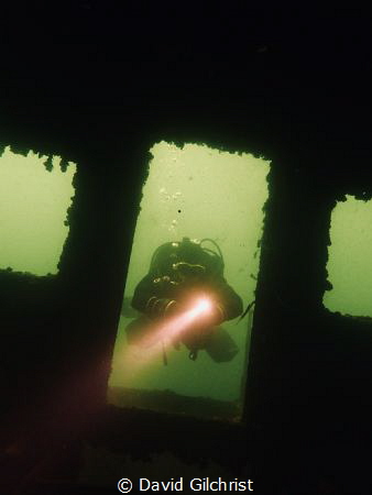 Diver prepares to enter sunken boat. by David Gilchrist 