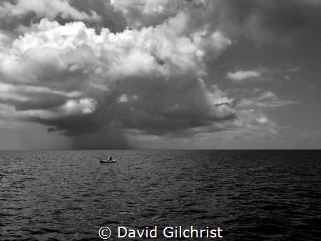 Honduran fisherman on the  waters off Roatan as storm app... by David Gilchrist 