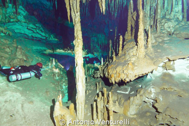 divers lighting the beauty of the Dreamgate cave, Riviera... by Antonio Venturelli 