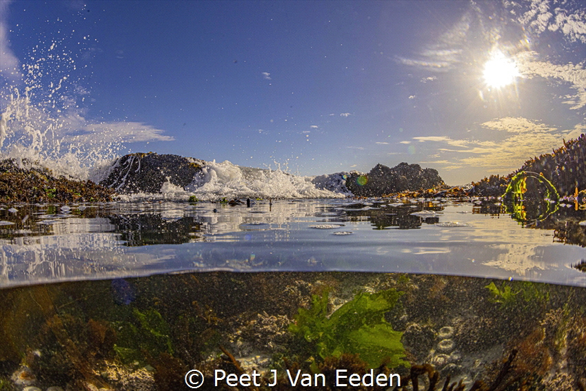 Breaking waves filling a rockpool in the ongoing cycle of... by Peet J Van Eeden 
