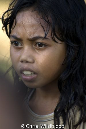 Girl in fishing village near Wakatobi. by Chris Wildblood 