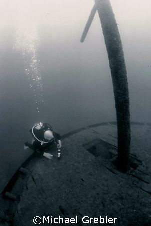A diver checks his gauges at the stern of the Rothesay wh... by Michael Grebler 