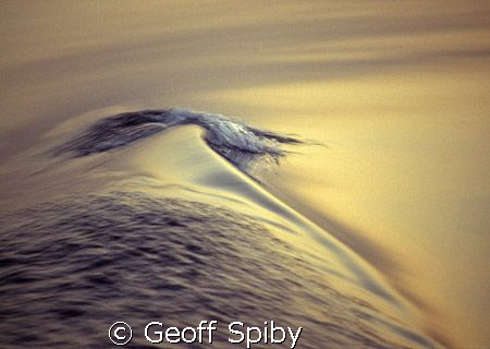 tiny wave caused by the boats wake on a flat sea by Geoff Spiby 