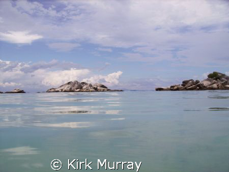 Surfacing to a millpond sea with an almost cartoon panora... by Kirk Murray 