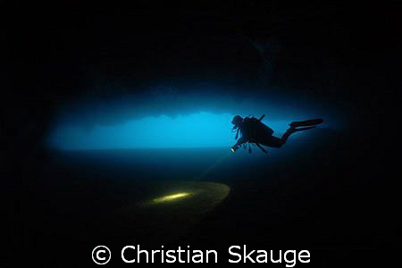 A diver in one of the caves on the west coast of the isla... by Christian Skauge 