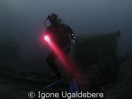 diving the wreck of the Thistlegorm. Diver with torch. by Igone Ugaldebere 
