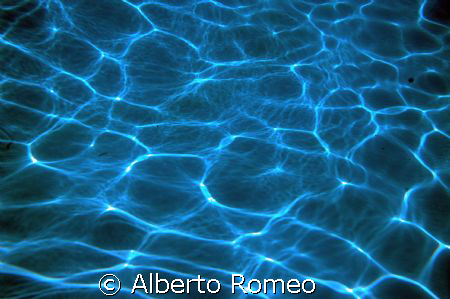 REFRACTION OF SUN RAYS ON THE SAND BOTTOM IN SHALLOW WATERS by Alberto Romeo 