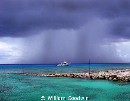 Rain... Reef Divers boat moored at Buccaneer Reef, Cayman... by William Goodwin 