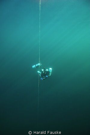 Technical diver at deco stop in crystal clear water by Harald Fauske 