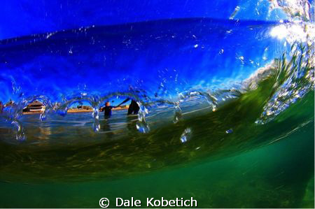 Veiw from under neath breaking wave, Father takes son int... by Dale Kobetich 