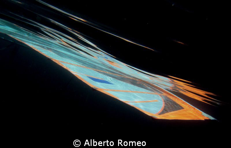 The sail of a windsurf underwater reflecting on the surfa... by Alberto Romeo 