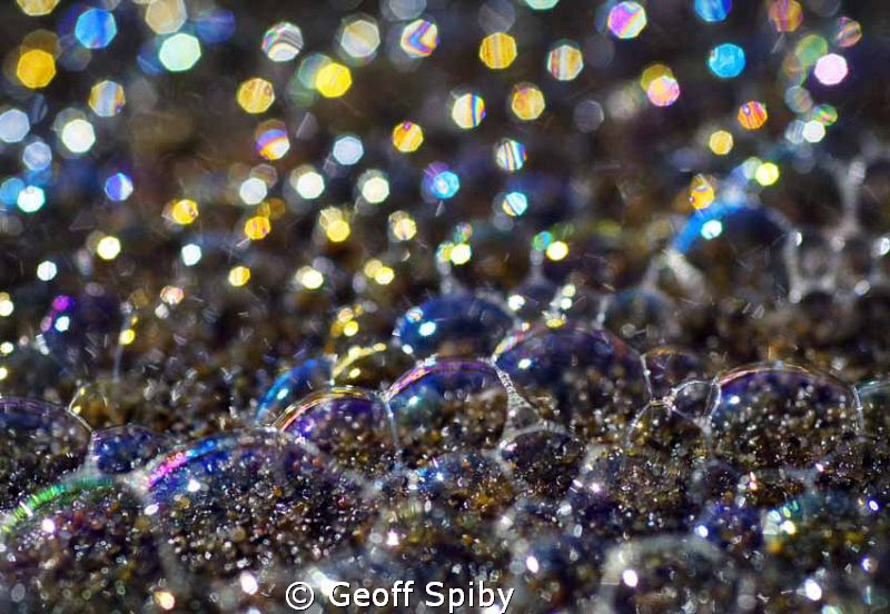 abstract colours from a close up of the foam bubbles on t... by Geoff Spiby 
