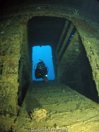 Evelio penetrating the wreck, Wit shoal, St. Thomas. by Abimael Márquez 