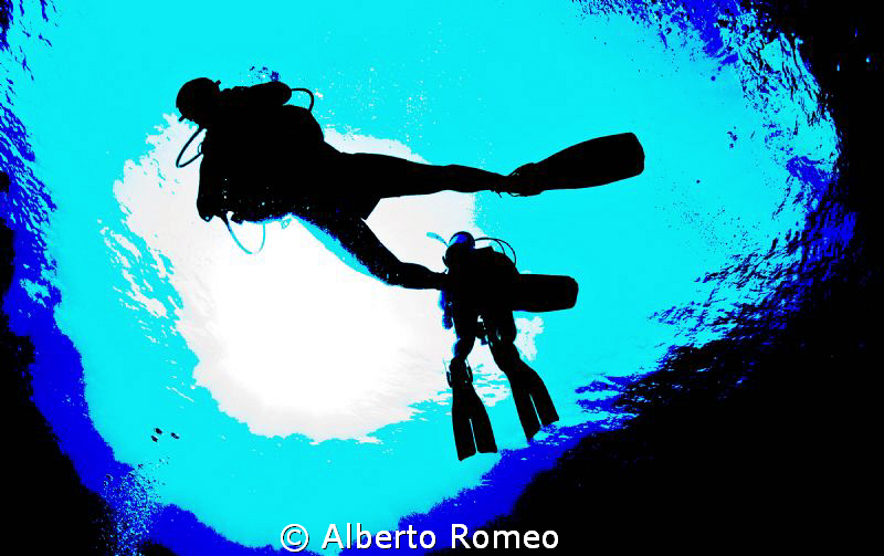 Divers in backlight by Alberto Romeo 