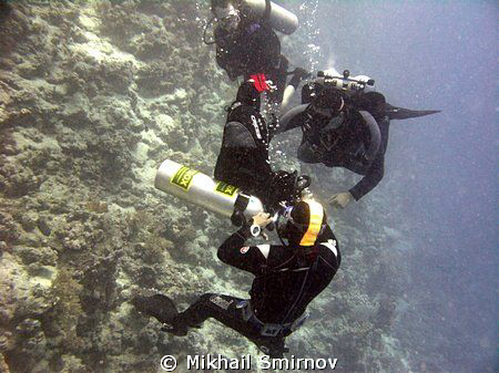 "I can fix it on-the-fly!"   
Diveguide checking his fir... by Mikhail Smirnov 
