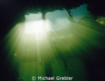 Looking up at the light beams coming through the fisherme... by Michael Grebler 