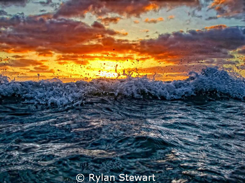 A wave starts to break as the sun sets near Waikiki, HI by Rylan Stewart 