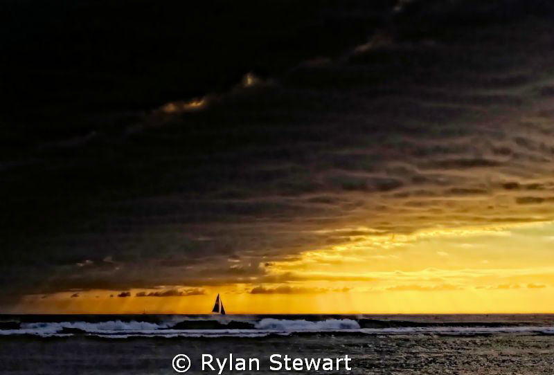 A lone sailboat outruns an impending storm in the waters ... by Rylan Stewart 