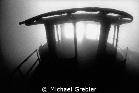 The sun bursts through the skeletal remains of the wheelh... by Michael Grebler 
