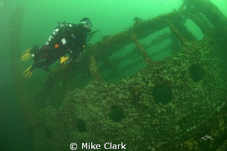 Diver fins past the bridge of the Hispania Wreck by Mike Clark 