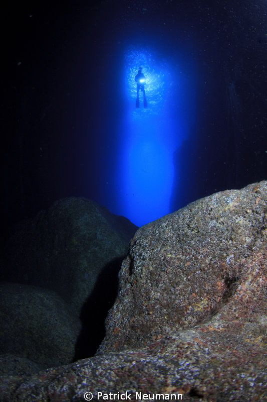 Diver in the entrance of a cave by Patrick Neumann 