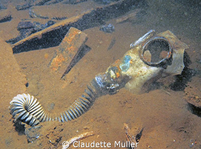 Gas mask deep in the hold of a Truk Lagoon wreck. by Claudette Muller 