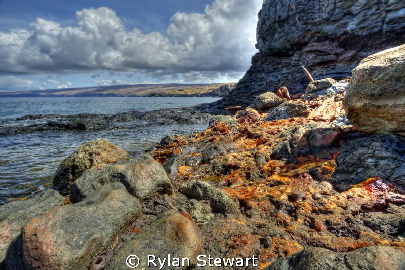 Scrap iron thrown over the cliff slowly rusts and melts i... by Rylan Stewart 