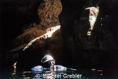 Cave diver surfacing in the cavern section of a flooded m... by Michael Grebler 