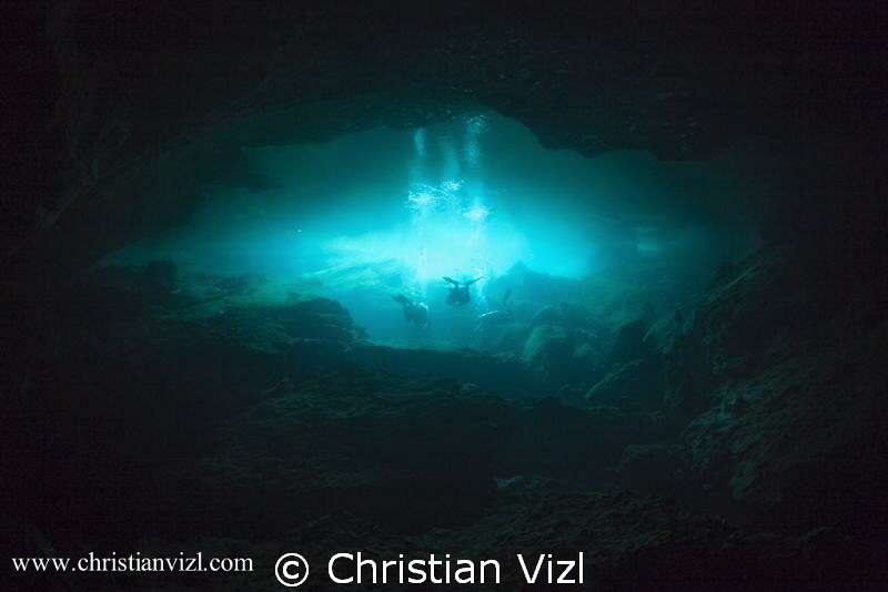 Cave divers exiting into the cavern area of a mexican Cen... by Christian Vizl 