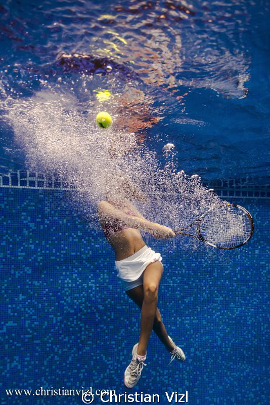 Samantha playing tenis underwater. by Christian Vizl 