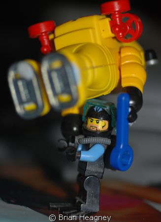 Lego diver prepares Playmobil diver for deep descent. by Brian Heagney 