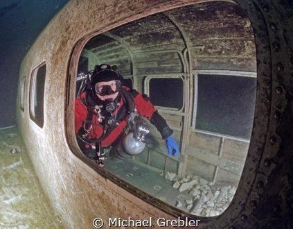 Diver inside airplane wreck in Morrison's Quarry under th... by Michael Grebler 