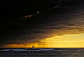 A lone sailboat outruns an impending storm in the waters off Oahu 