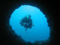 Damn, he found me! Rob on the other side of a swim through in Raja Ampat