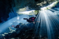 Diving through magnificent sunbeams in the cenotes of Mexico.