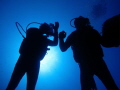 Silhouette of two divers by the wreck HMS cricket.
