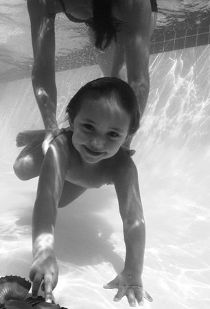 black and white image of child enjoying being underwater ... by Fiona Ayerst 