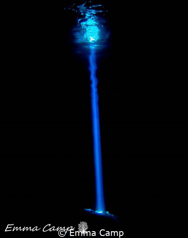 A beam of light shinning through a hole in a Cenote in Ca... by Emma Camp 