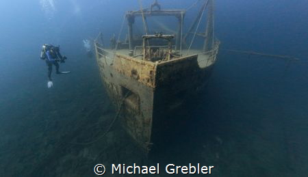 An U/W photographer checks his camera settings while hove... by Michael Grebler 