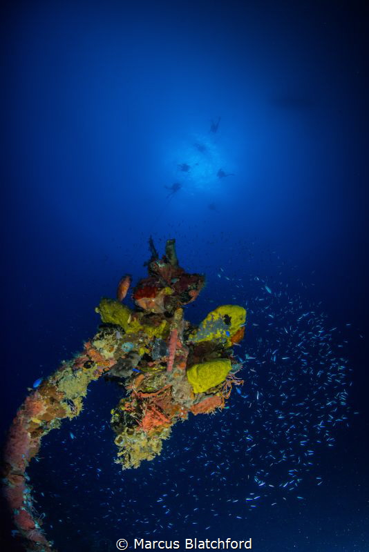 Lifeboat davit with decompressing divers in background by Marcus Blatchford 