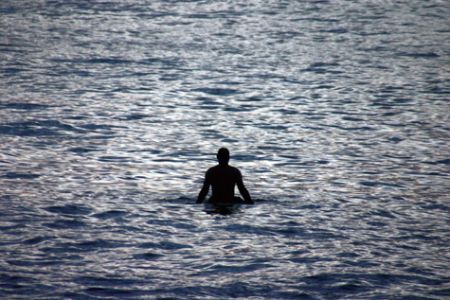 Waiting. The sun had already set, but this surfer just wo... by Mathew Cook 