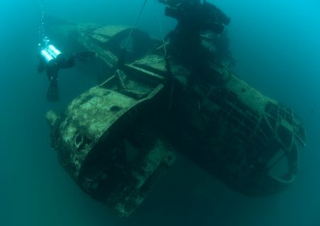 Diver swimming past the helicopter at Dutch Springs. by George Bouloukos 